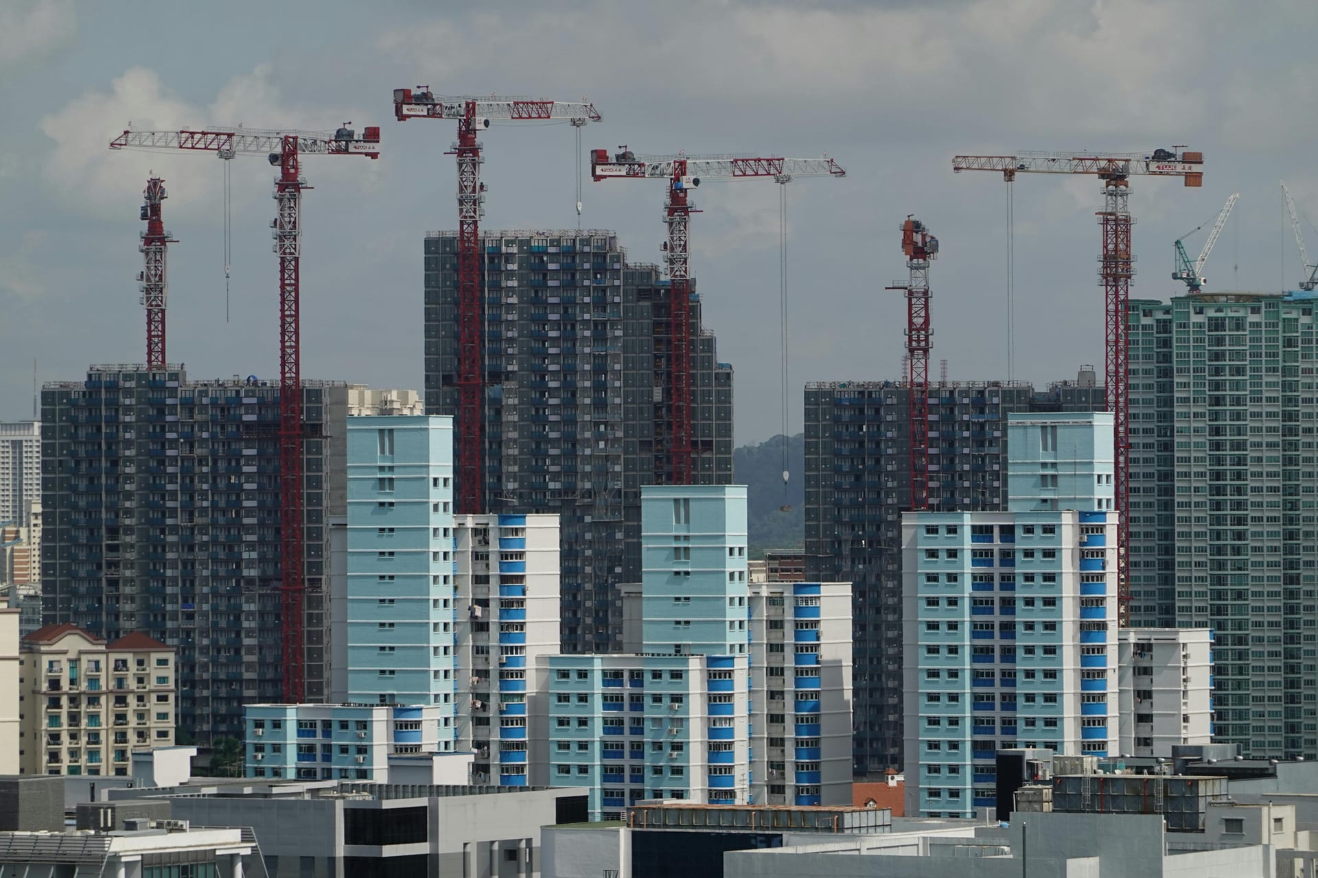 A young couple walking through a Singapore residential neighbourhood — first-time buyers planning their property purchase